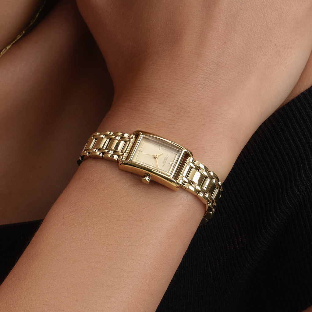 Gold watch on a wrist.