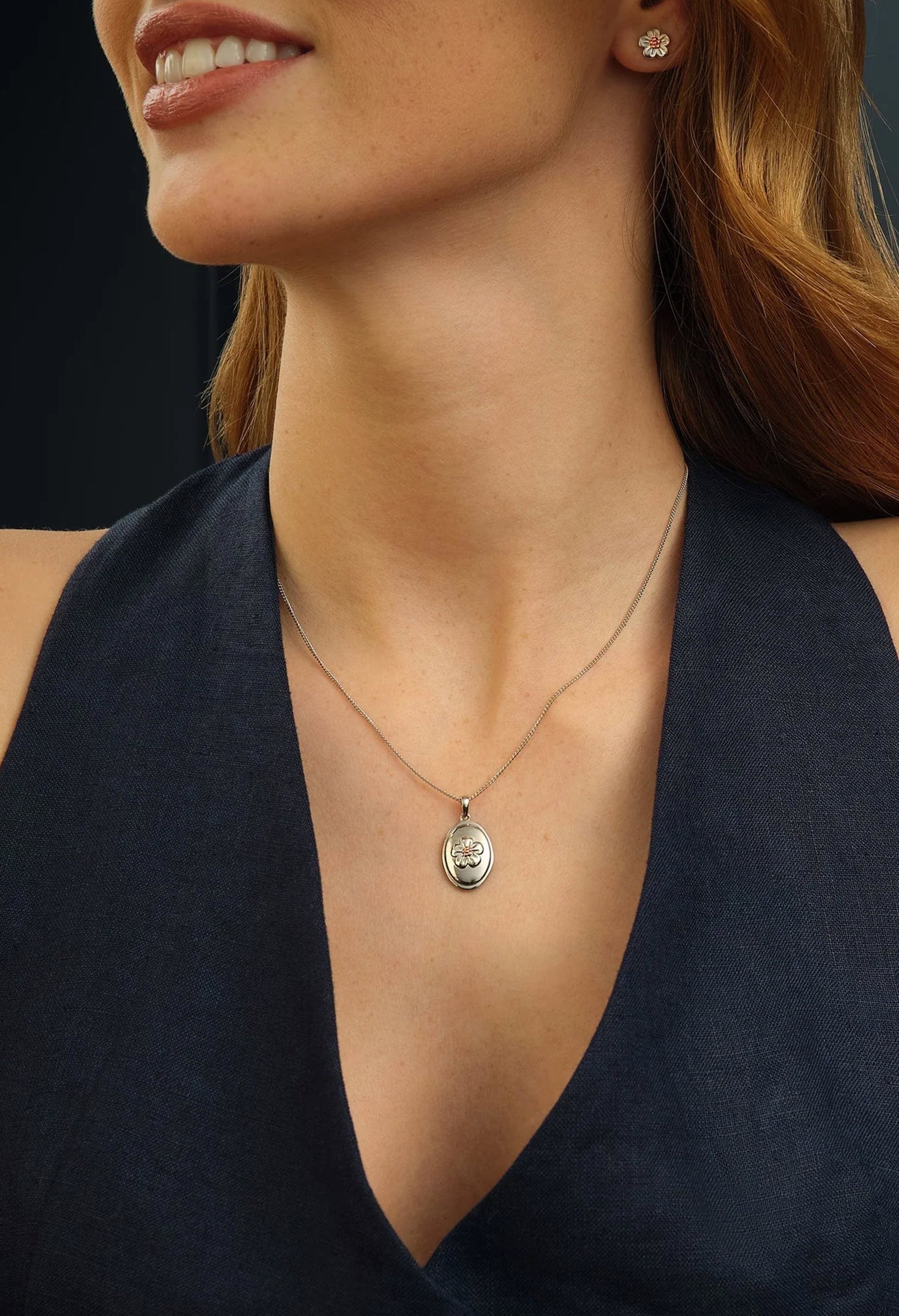 Woman wearing a Clogau Forget Me Knot pendant necklace. Elegant floral silver jewelry.