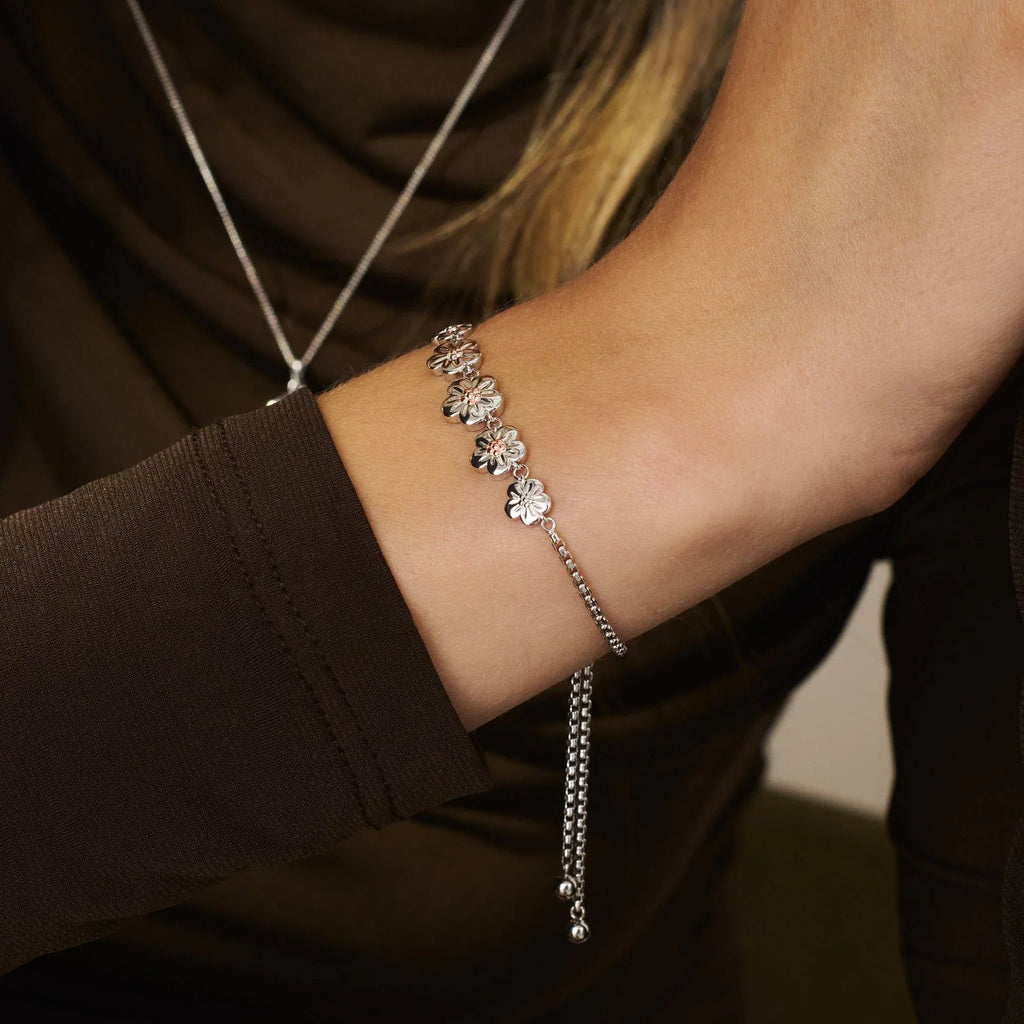 Woman wearing a silver flower bracelet.