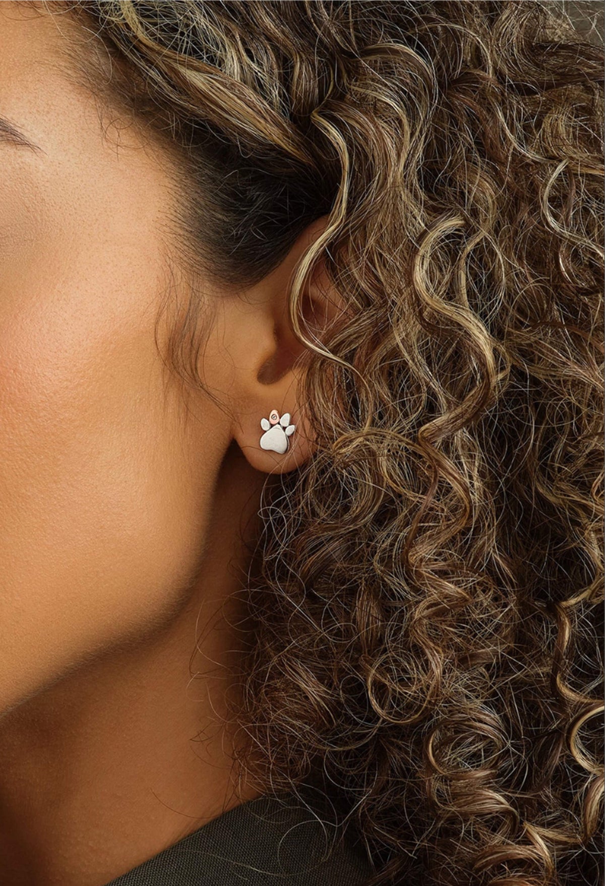 Close-up showcasing the Clogau Paw Prints stud earrings in sterling silver, with a subtle white topaz detail.