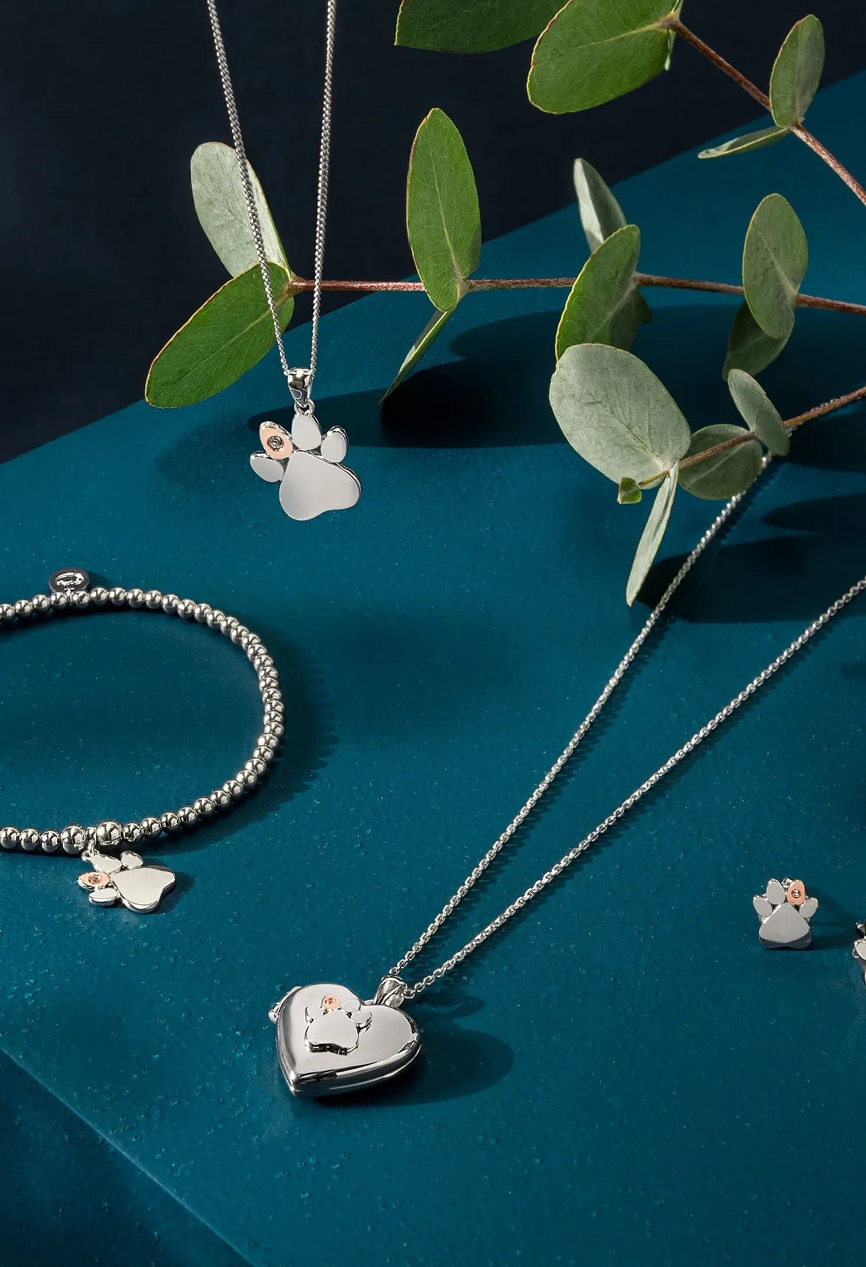 Clogau Paw Print Heart Locket with sterling silver chain, paw print bracelet and leaf accents.