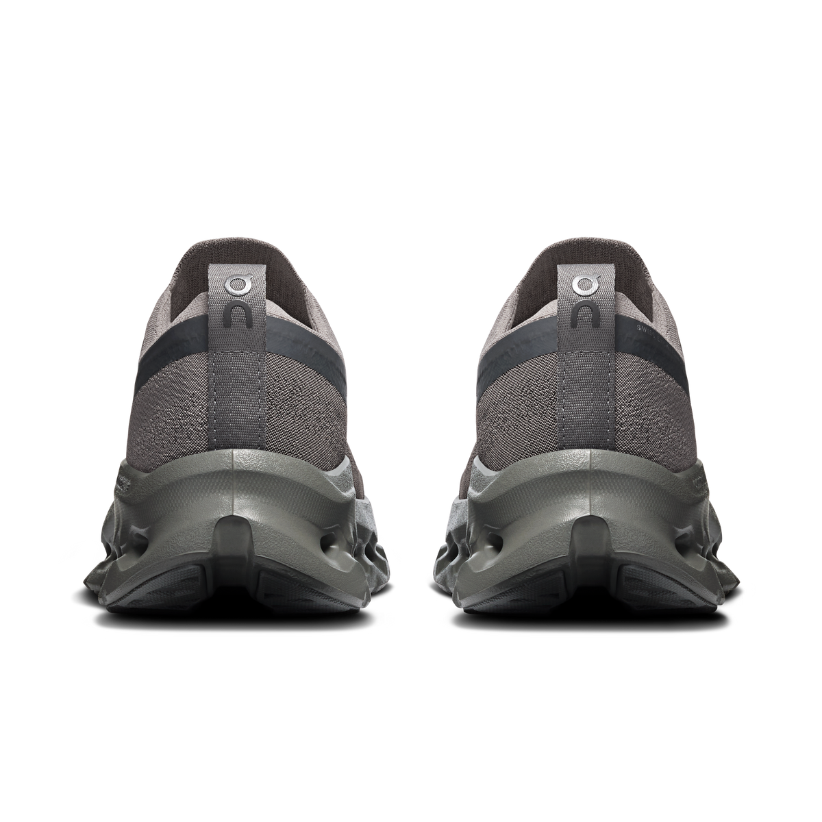 A pair of dark gray and black athletic sneakers shown from the rear, featuring textured knit uppers and chunky sculpted midsoles, set against a plain white background.