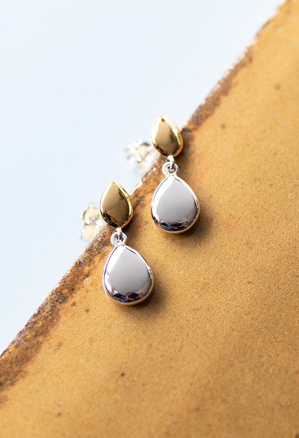 Elegant silver droplet earrings from Kit Heath's Golden Coast collection, detailed pebble stud design. Close-up product