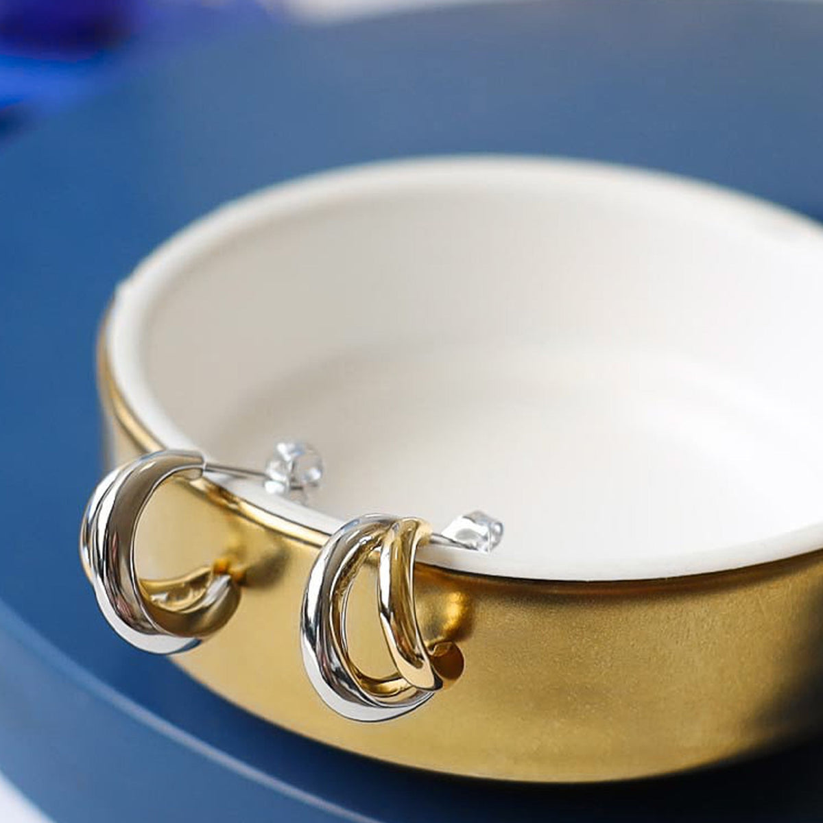 Kit Heath earrings, Bevel Cirque design. Twin hoop earrings with silver and gold links, displayed in dish.