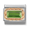 Nomination composable charm. Green baguette stone set in 9K rose gold on a steel link. Jewelry detail.