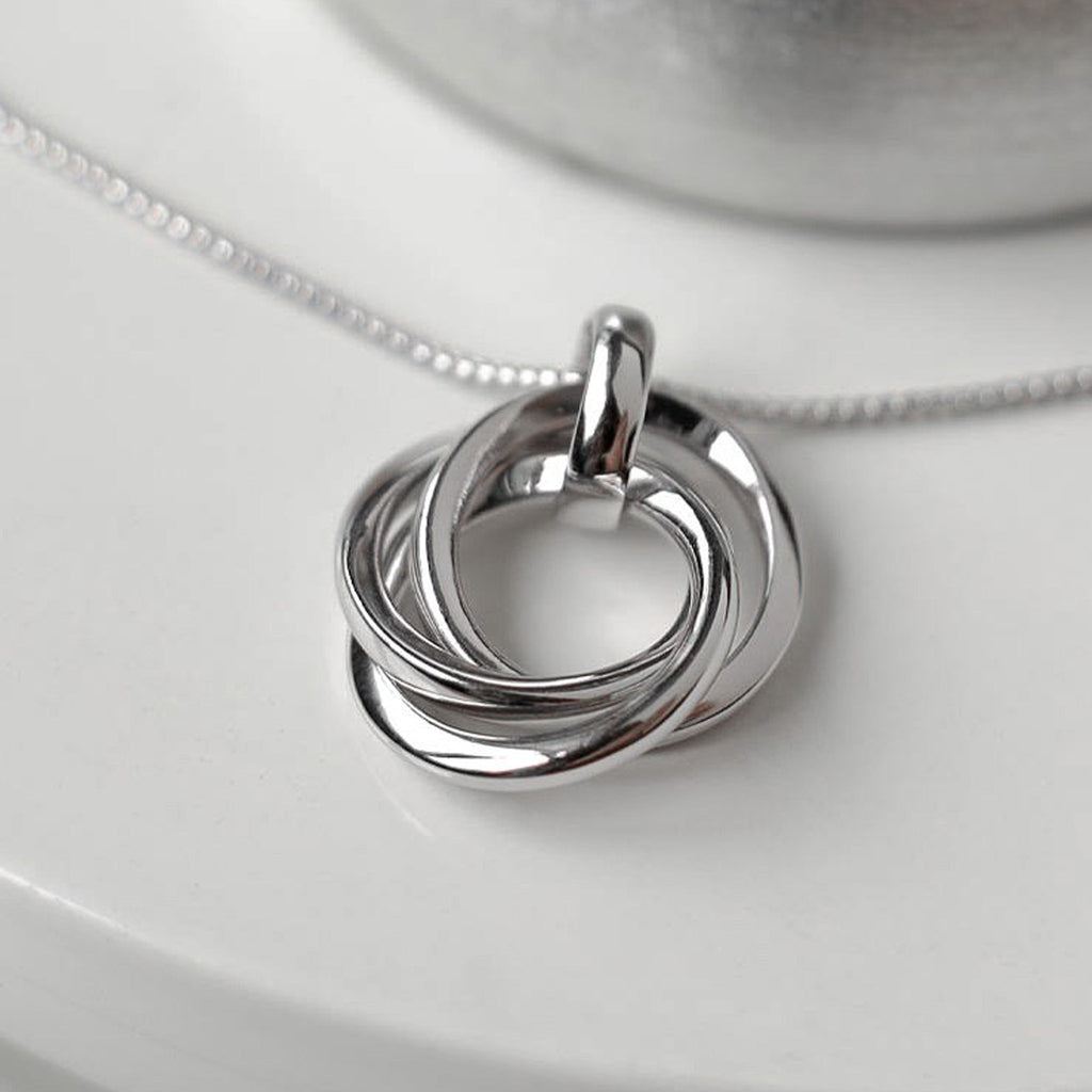 Close-up of the Kit Heath Bevel Trilogy Necklace, silver rhodium plated, showcasing the intertwined circles pendant and