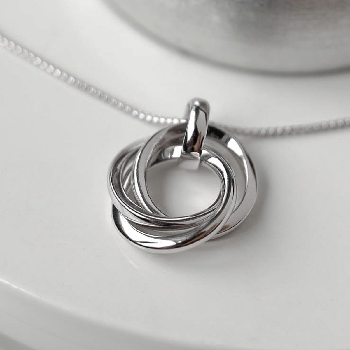 Close-up of the Kit Heath Bevel Trilogy Necklace, silver rhodium plated, showcasing the intertwined circles pendant and
