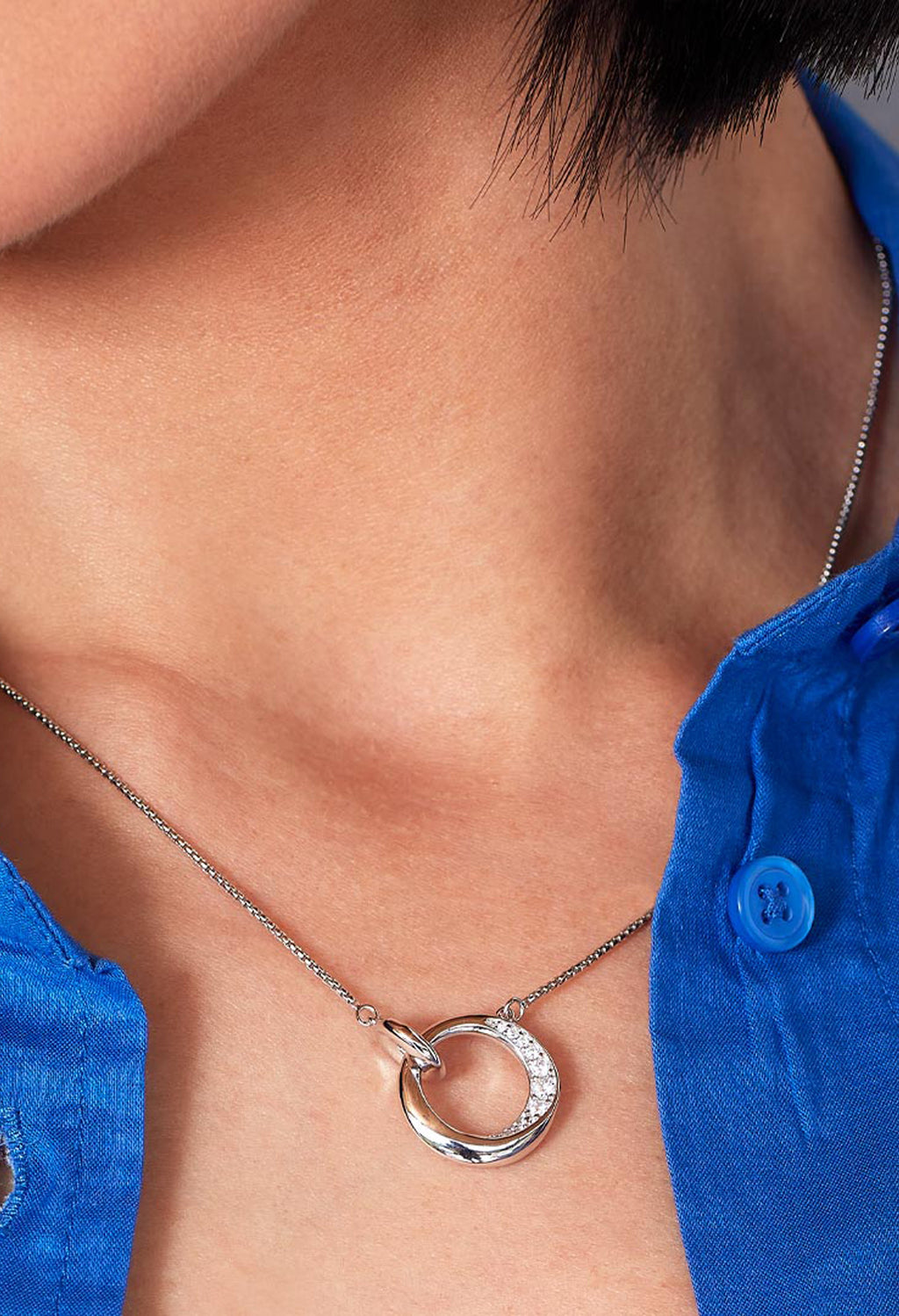 Close-up showcasing Kit Heath Bevel Cirque necklace. Silver chain, circle pendant with pave CZ detail. Perfect jewelry gift.