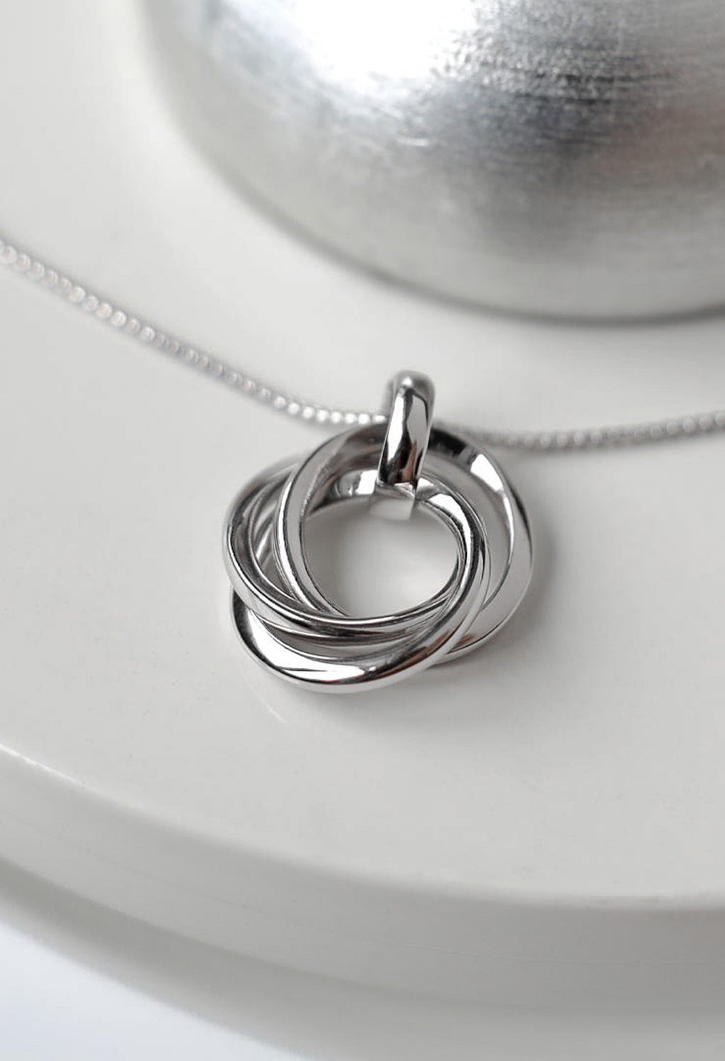 Close-up of the Kit Heath Bevel Trilogy Necklace, silver rhodium plated, showcasing the intertwined circles pendant and