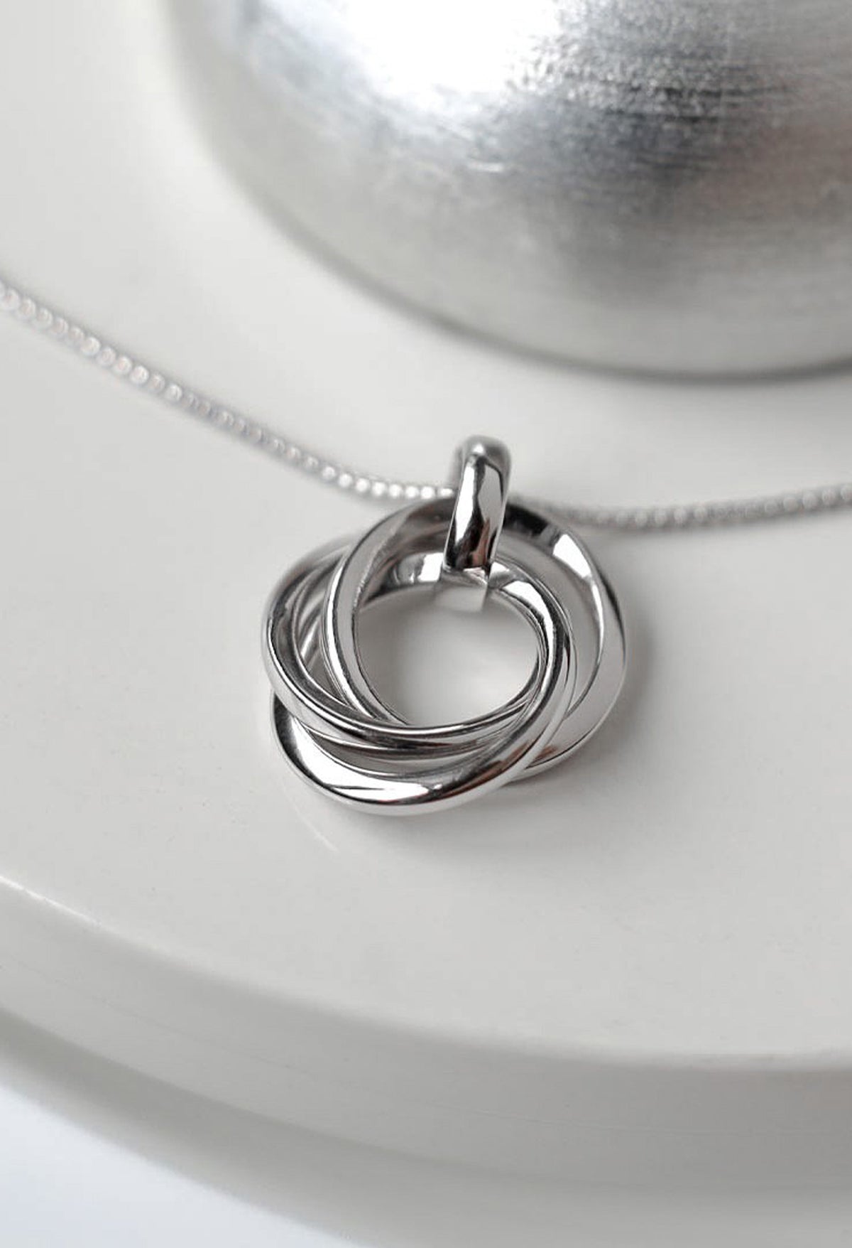 Close-up of the Kit Heath Bevel Trilogy Necklace, silver rhodium plated, showcasing the intertwined circles pendant and