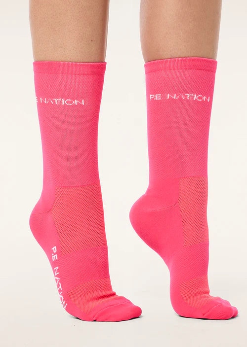 Pink socks with 'PE Nation' branding on a white background