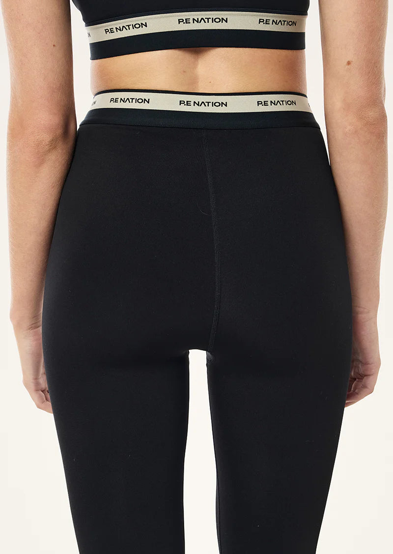 Black leggings with PE NATION waistbands on a white background