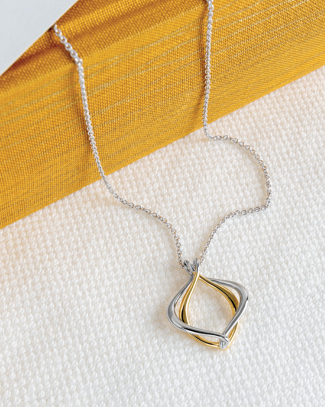Alicia Golden Petite Necklace on a styled background