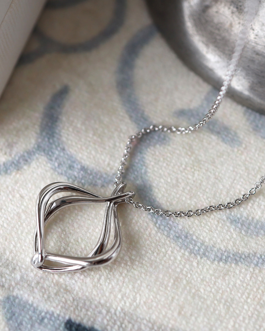 Alicia Petite Necklace on a styled background