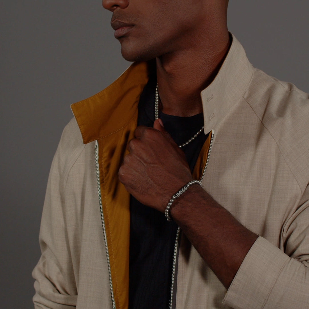 A stylish BOSS bracelet showcased on a model, highlighting the stainless steel design and menswear fashion aesthetic.