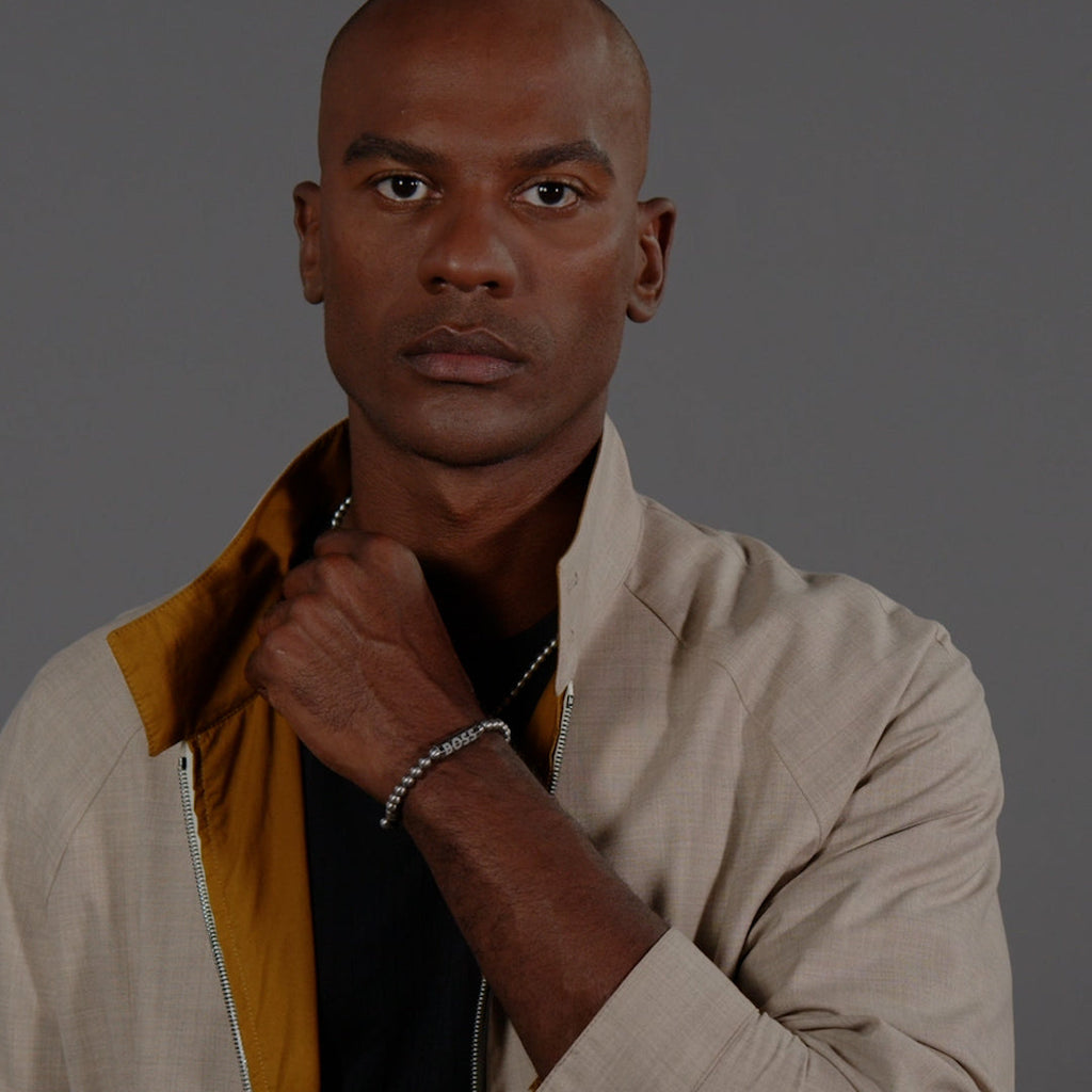 Man wearing a BOSS stainless steel bracelet. This beaded design adds a touch of modern style to any look.