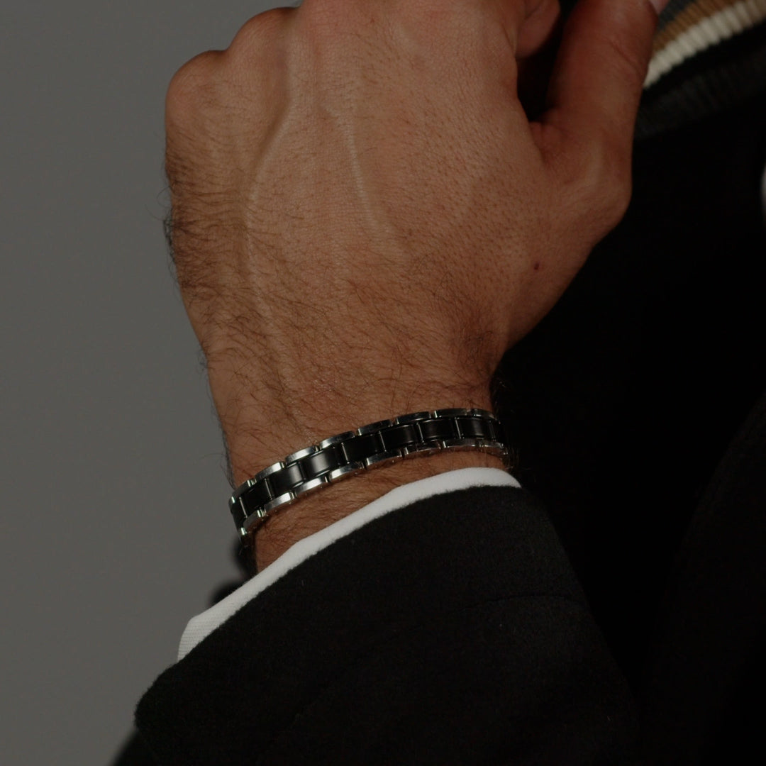 Close-up of BOSS black and stainless steel bracelet on wrist, showcasing the metal link design and polished finish.