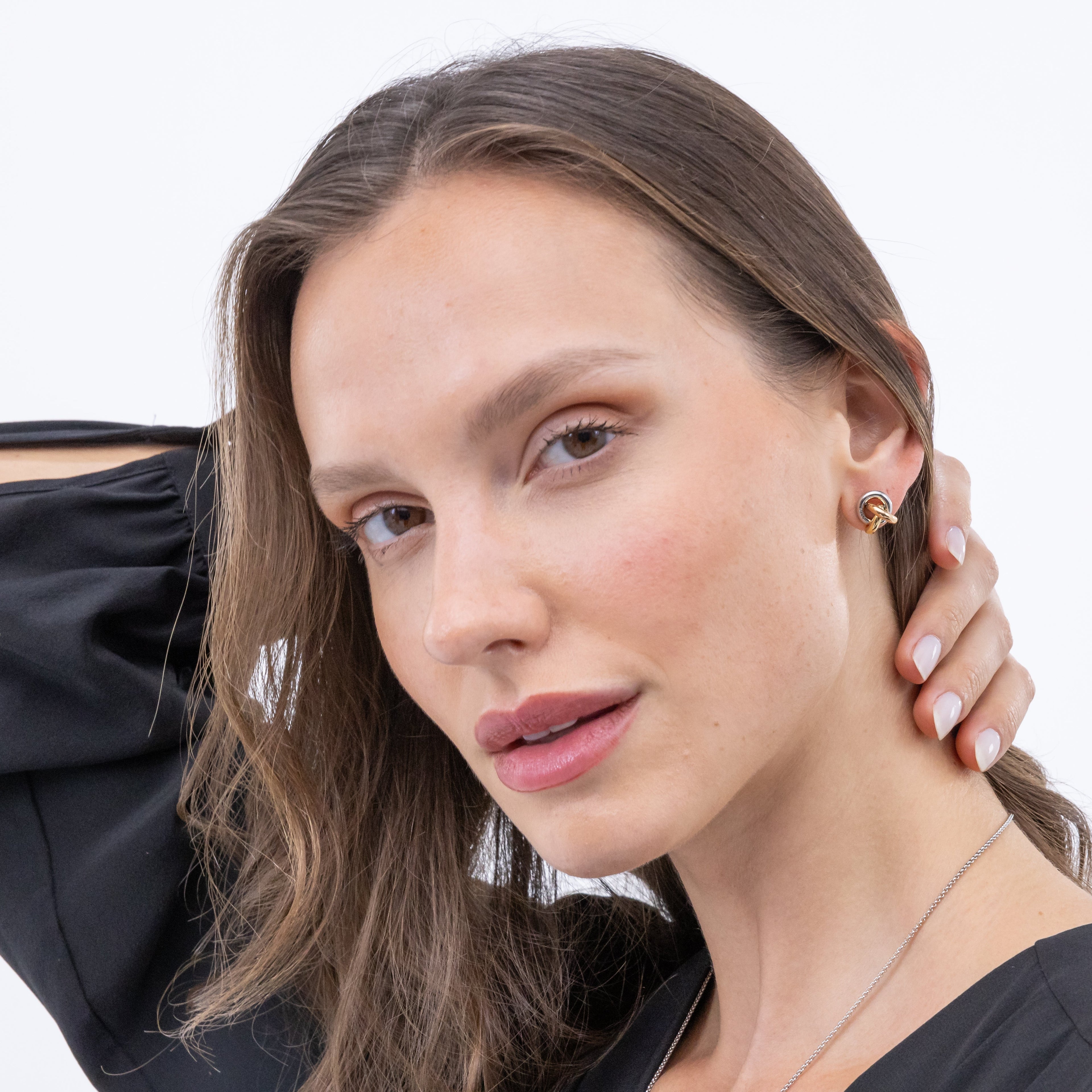 Woman wearing earrings and a black top.