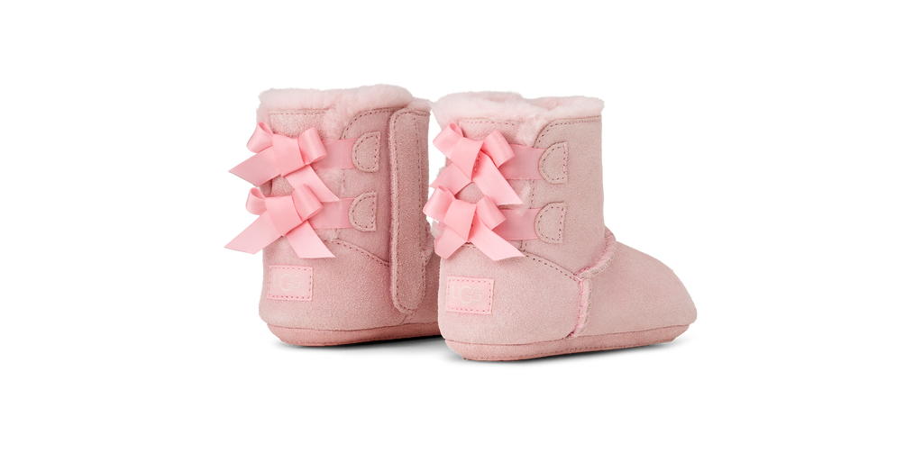 Pair of pink baby boots with bows on a white background