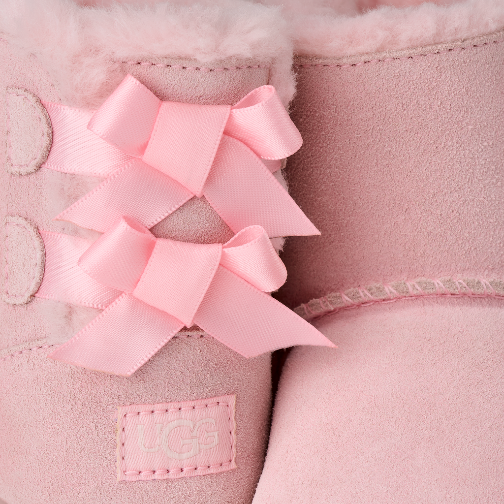 Close-up of pink UGG boot with a bow detail