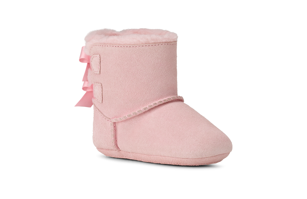 Pink baby bootie with a bow on a white background