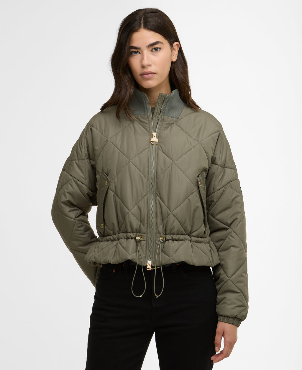 Woman wearing a green quilted jacket on a white background