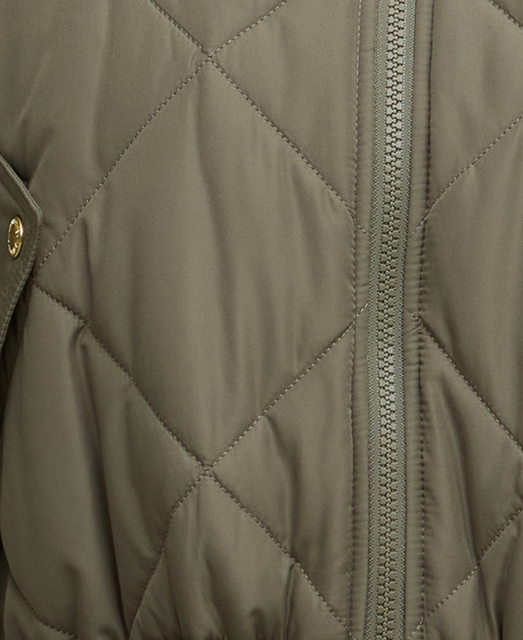 Close-up of a quilted jacket with a zipper and button detail.