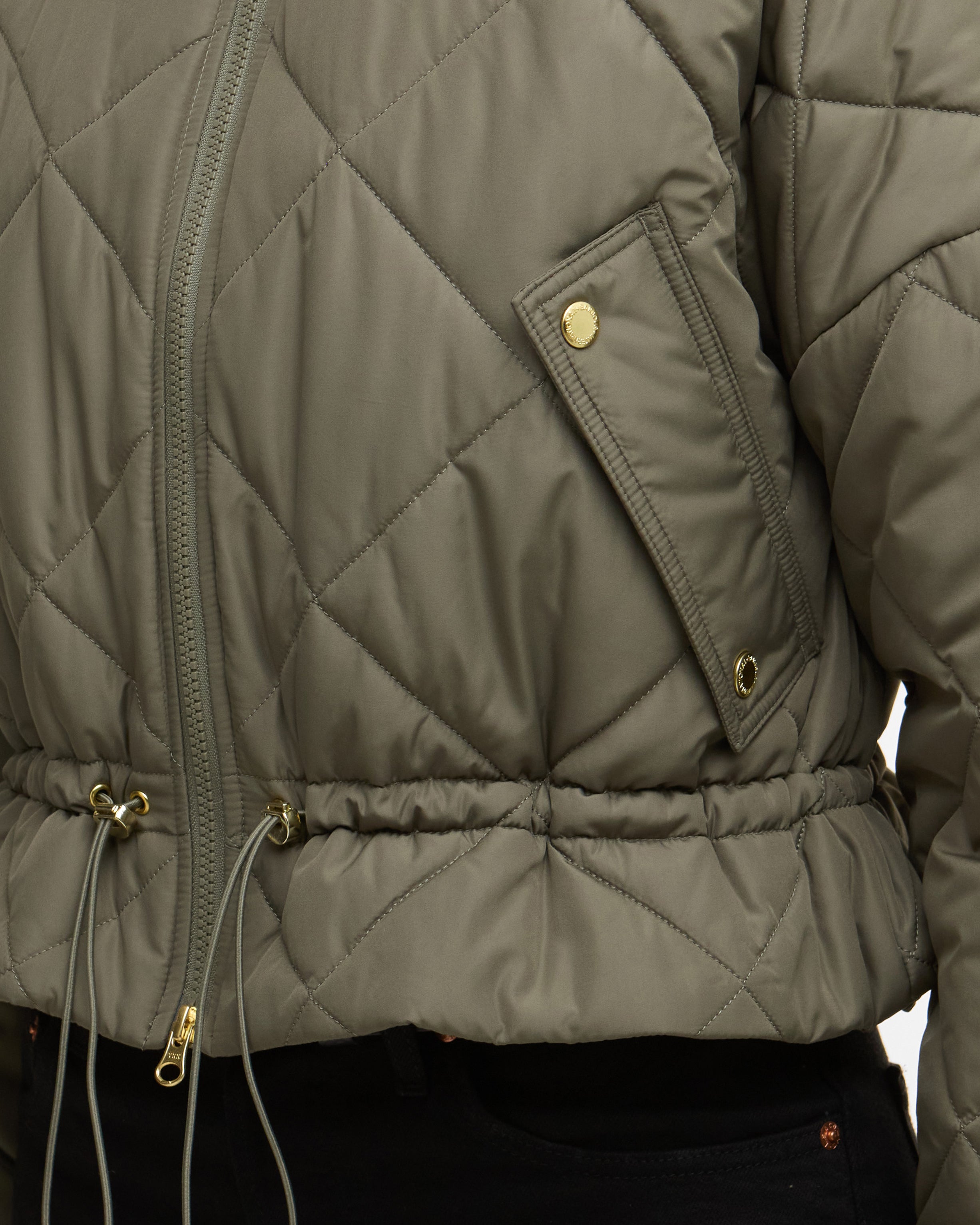 Quilted jacket with a focus on the quilted pattern and gold zippers.