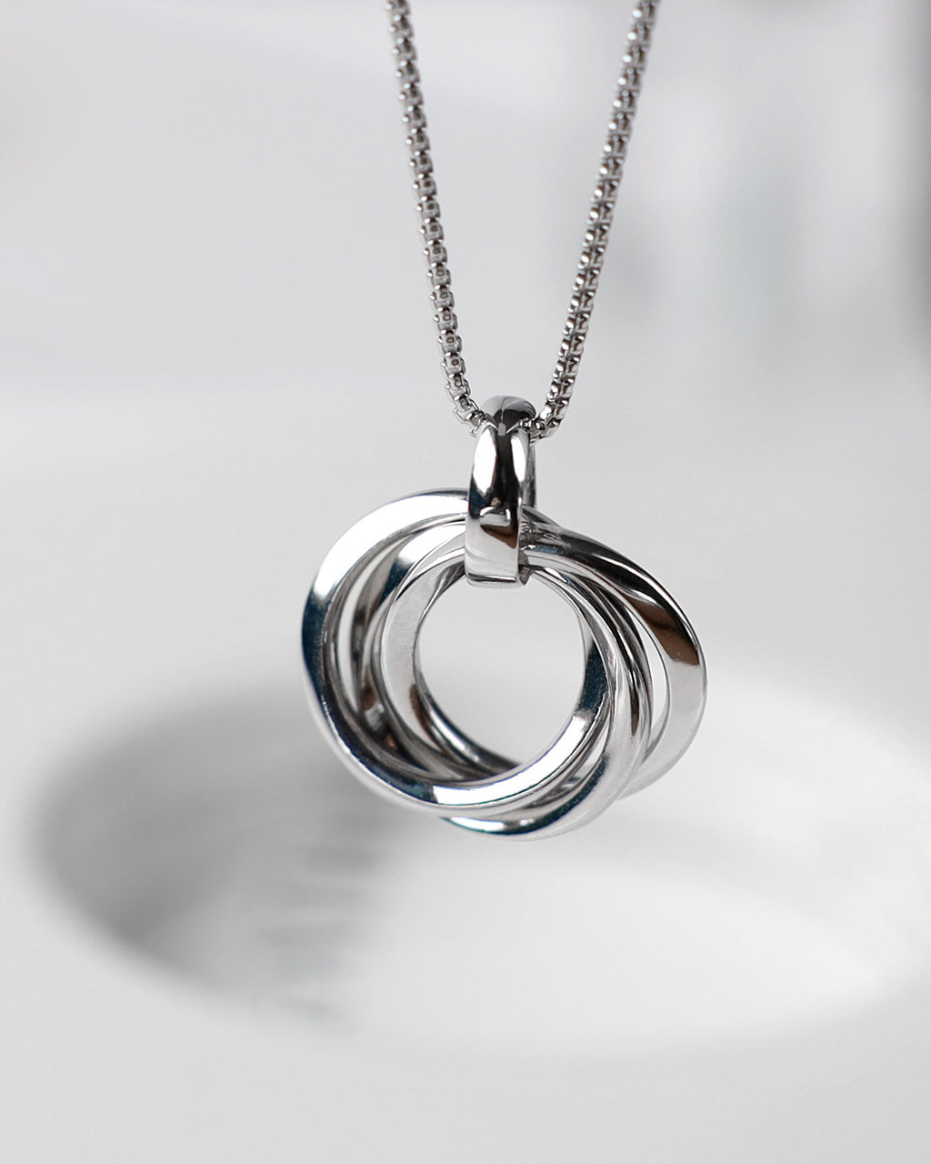 Bevel Trilogy Necklace on a styled background