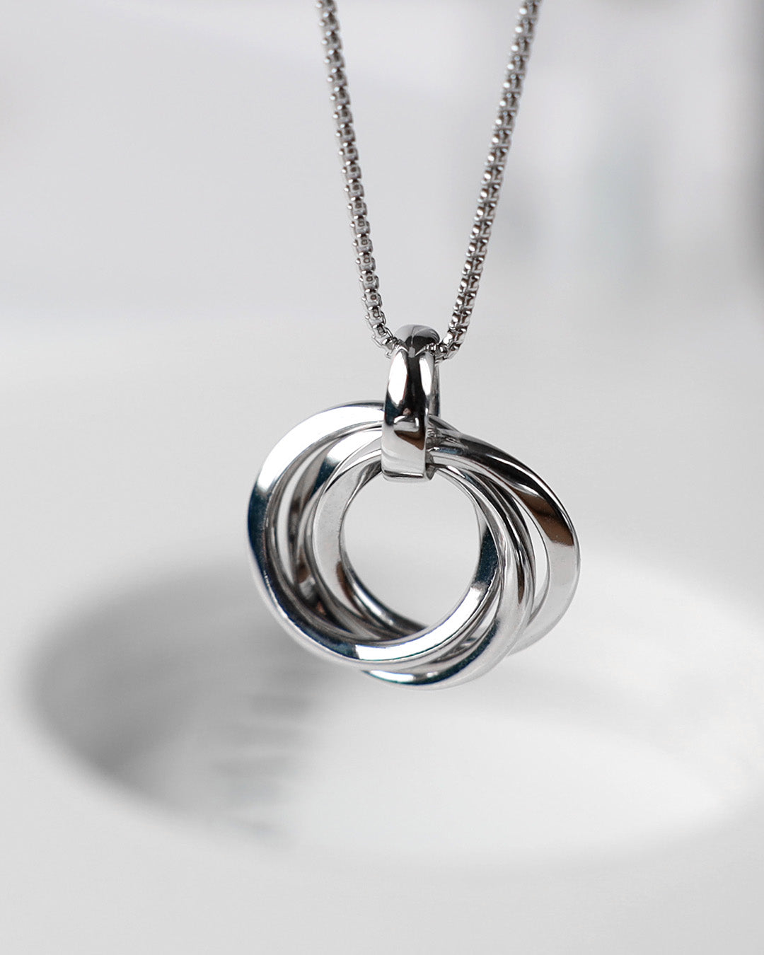 Bevel Trilogy Necklace on a styled background