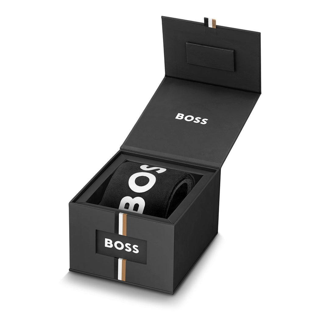 BOSS Lucy watch packaging. Open black gift box with "BOSS" branding revealing a rolled watch bracelet inside.
