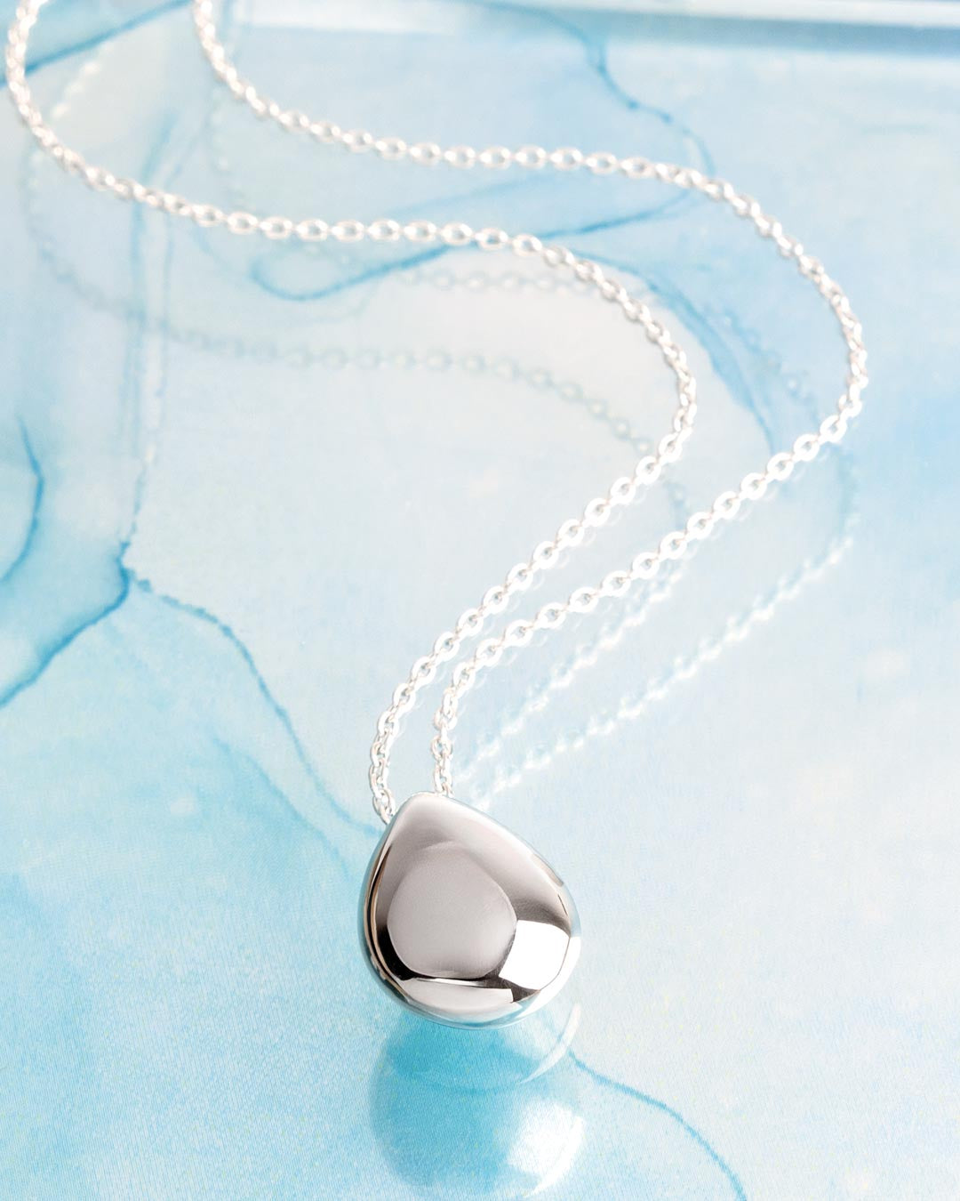 Coast Pebble Smooth Grande Necklace on a styled background