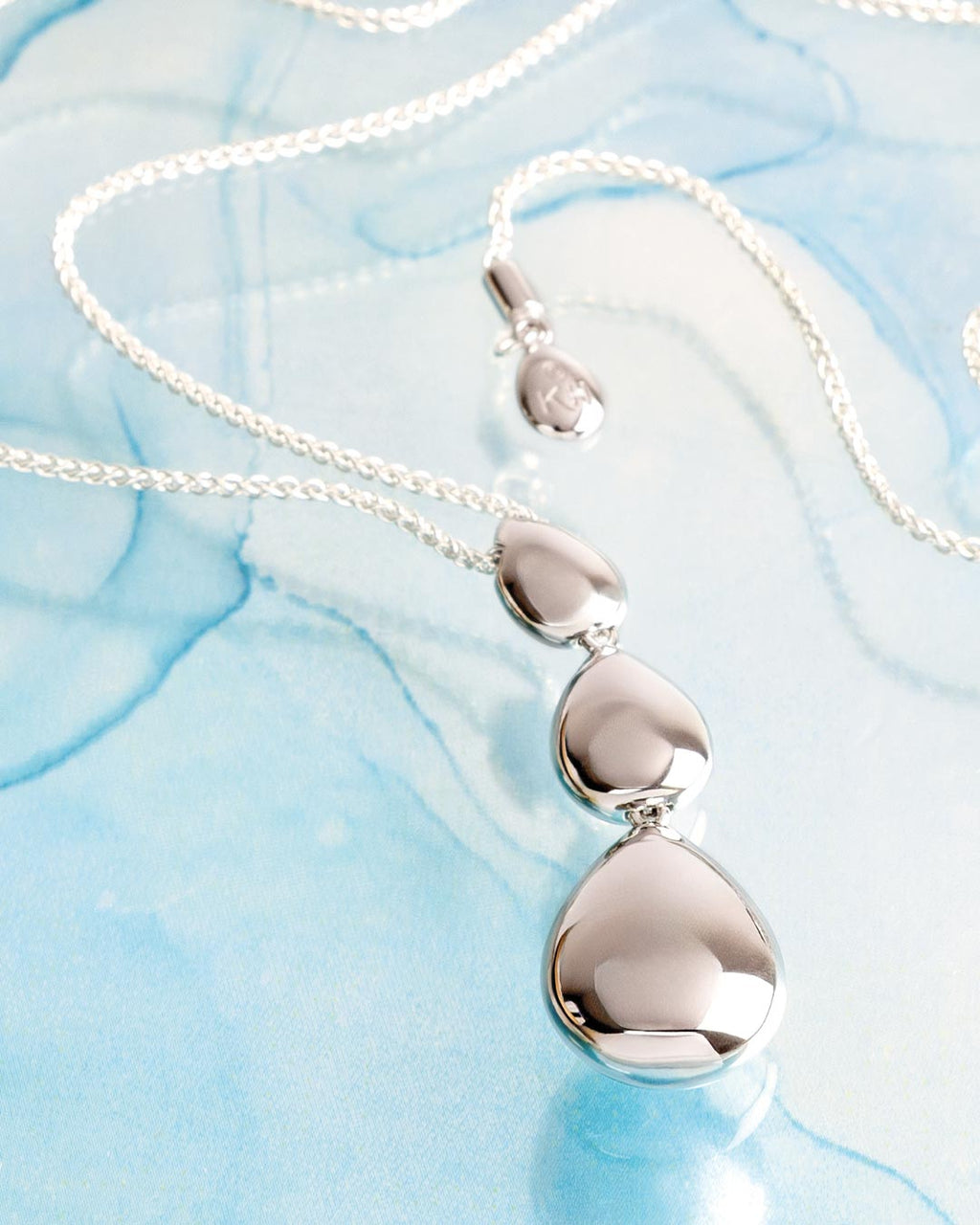 Coast Pebble Smooth Triple Grande Toggle Necklace on a styled background