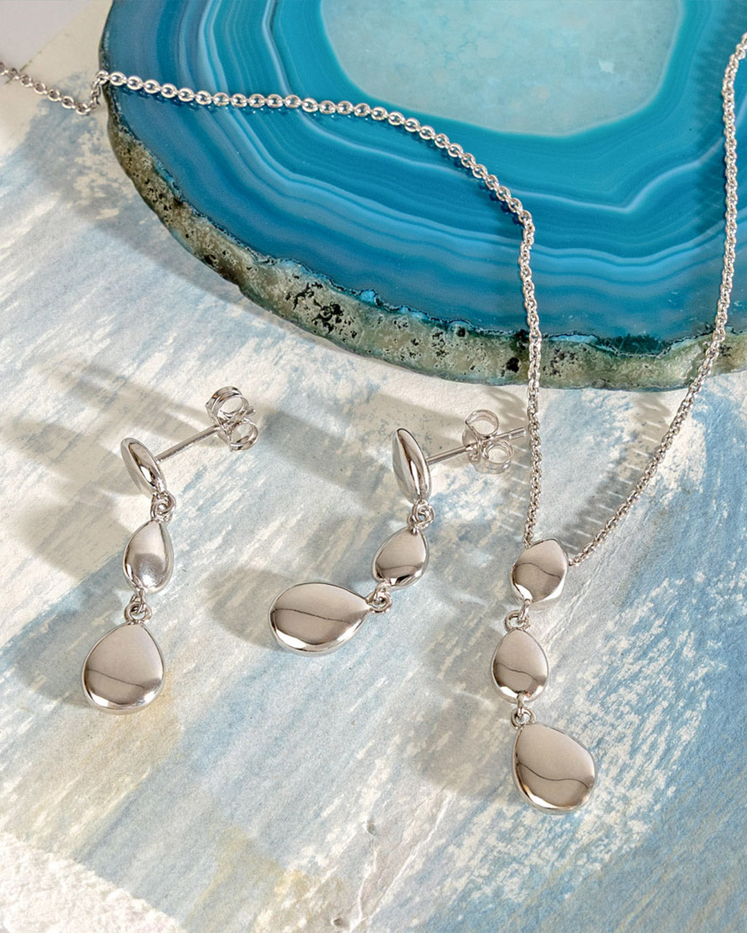 Coast Pebble Triple Linking Pebbles Necklace on a styled background