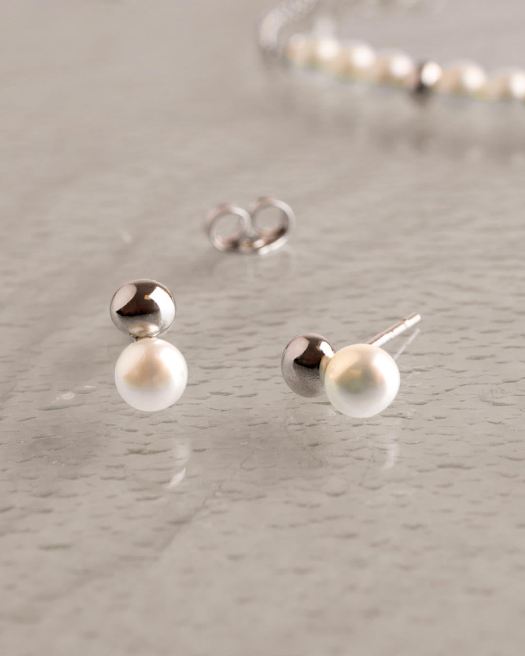 Coast Tumble Pearl Stud Earrings on a styled background