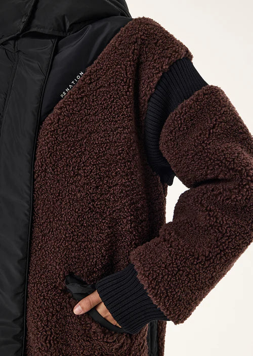 Close-up of a brown sherpa-lined jacket with black sleeves on a white background