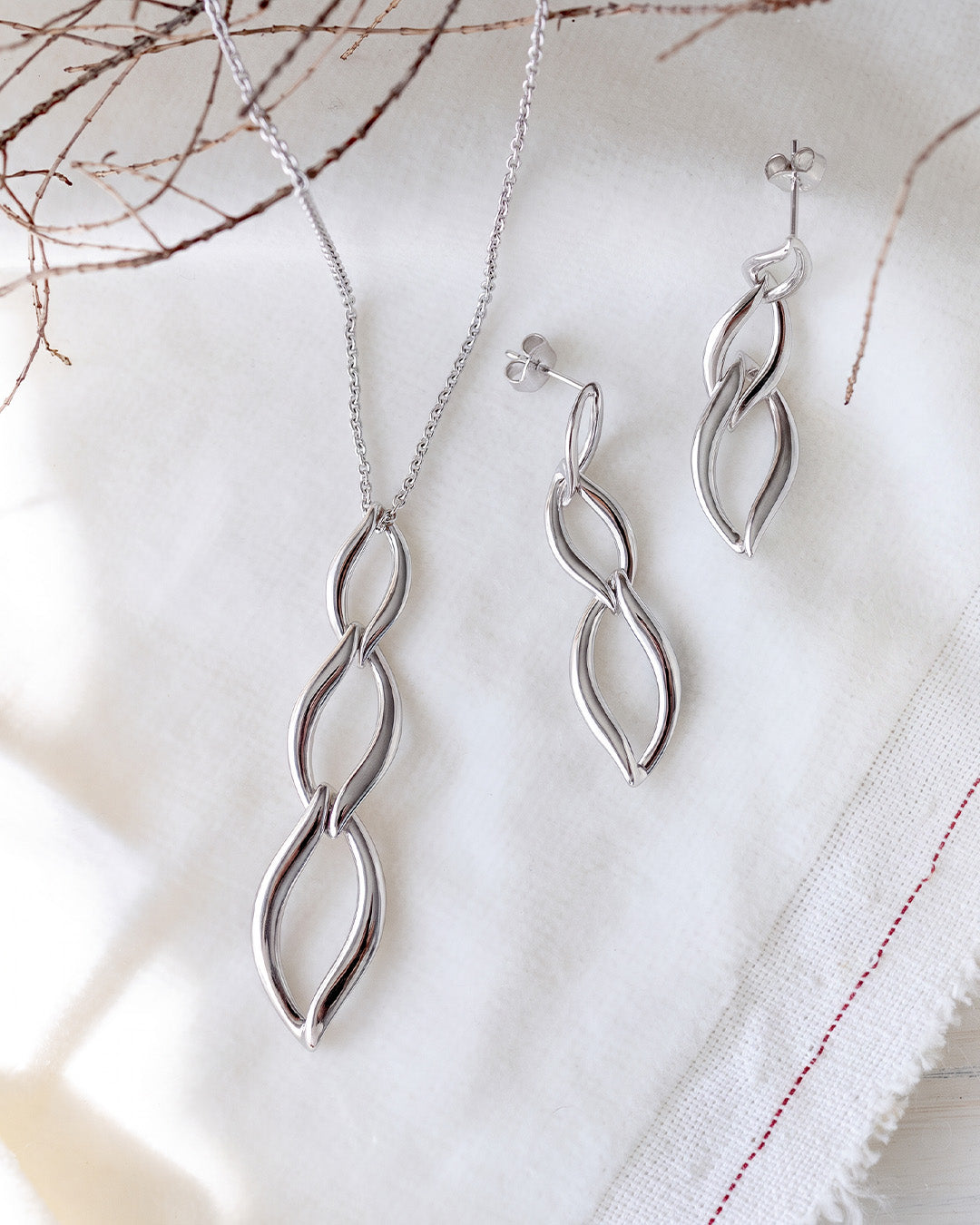 Entwine Twine Link Trio Necklace on a styled background