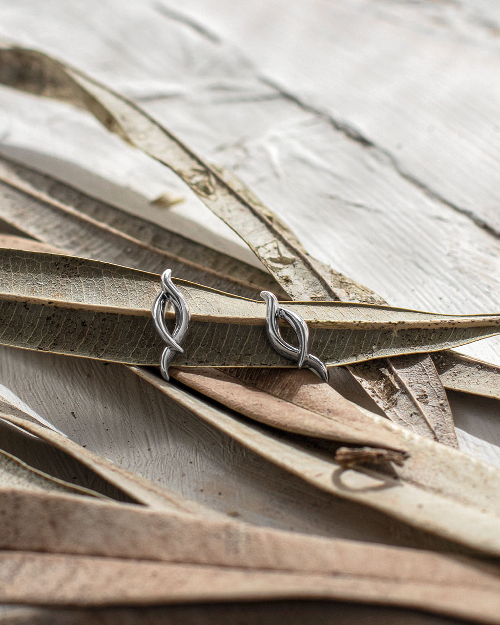 Entwine Twine Twist Statement Stud Earrings on a styled background