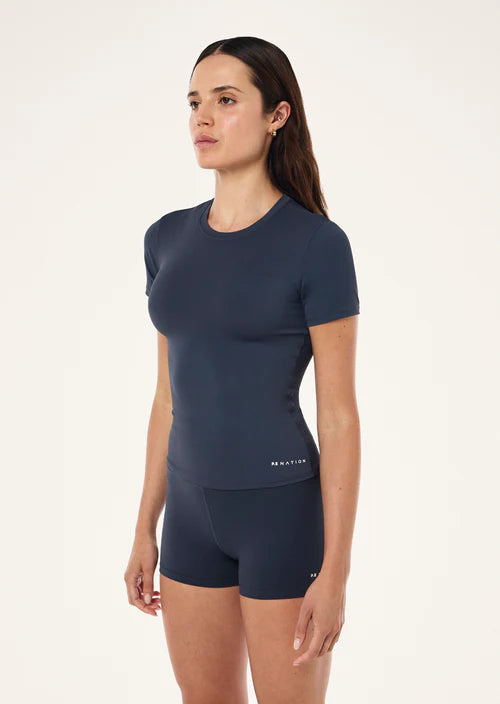 Woman wearing a navy athletic outfit on a white background
