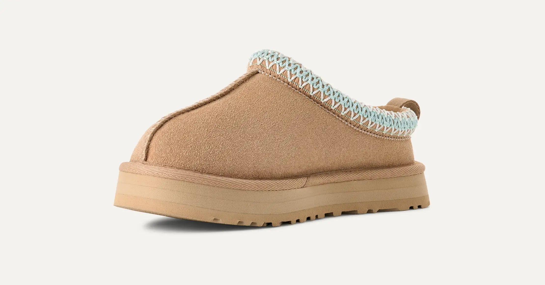 Tan slipper with textured trim on a white background