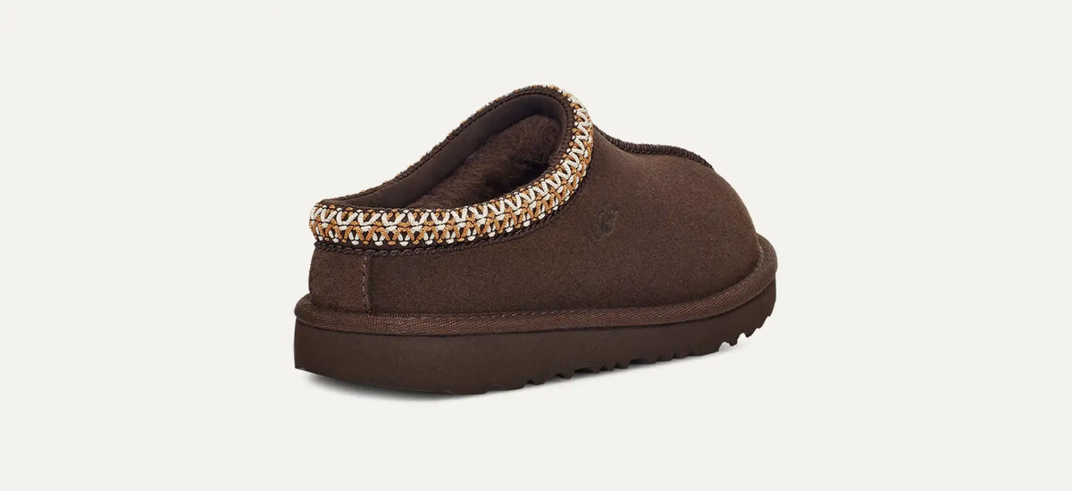 Brown slipper with decorative trim on a light gray background