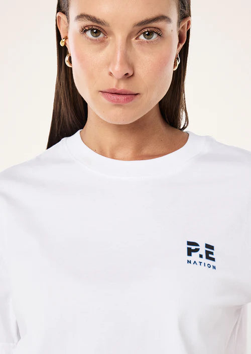Person wearing a white t-shirt with a logo on a light background