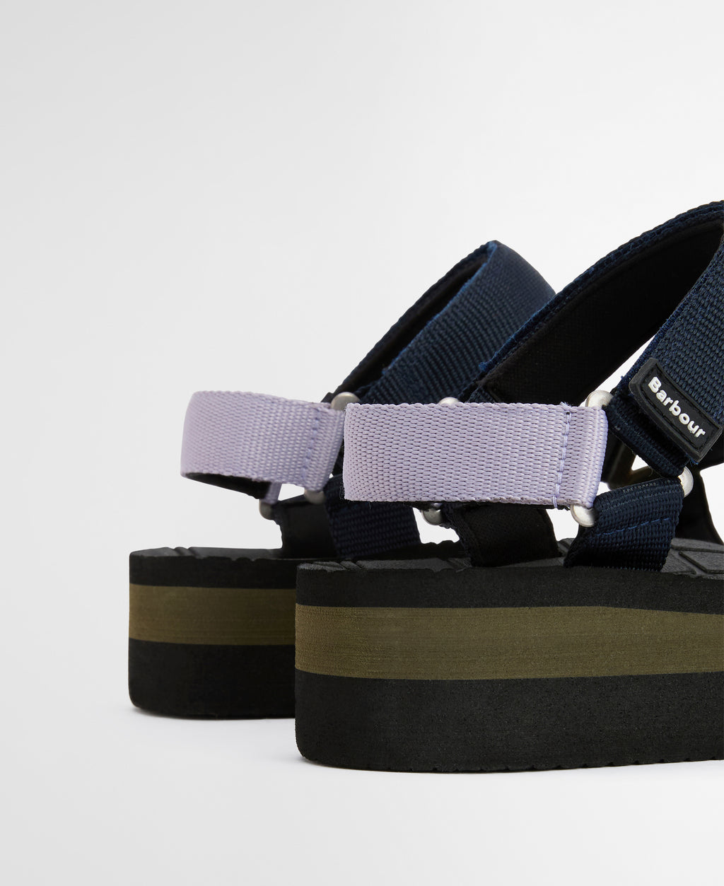 Black and green platform sandals with multiple straps on a light gray background
