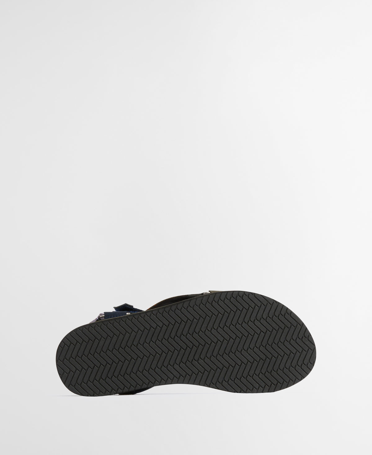 Black sandal with a textured sole on a light gray background