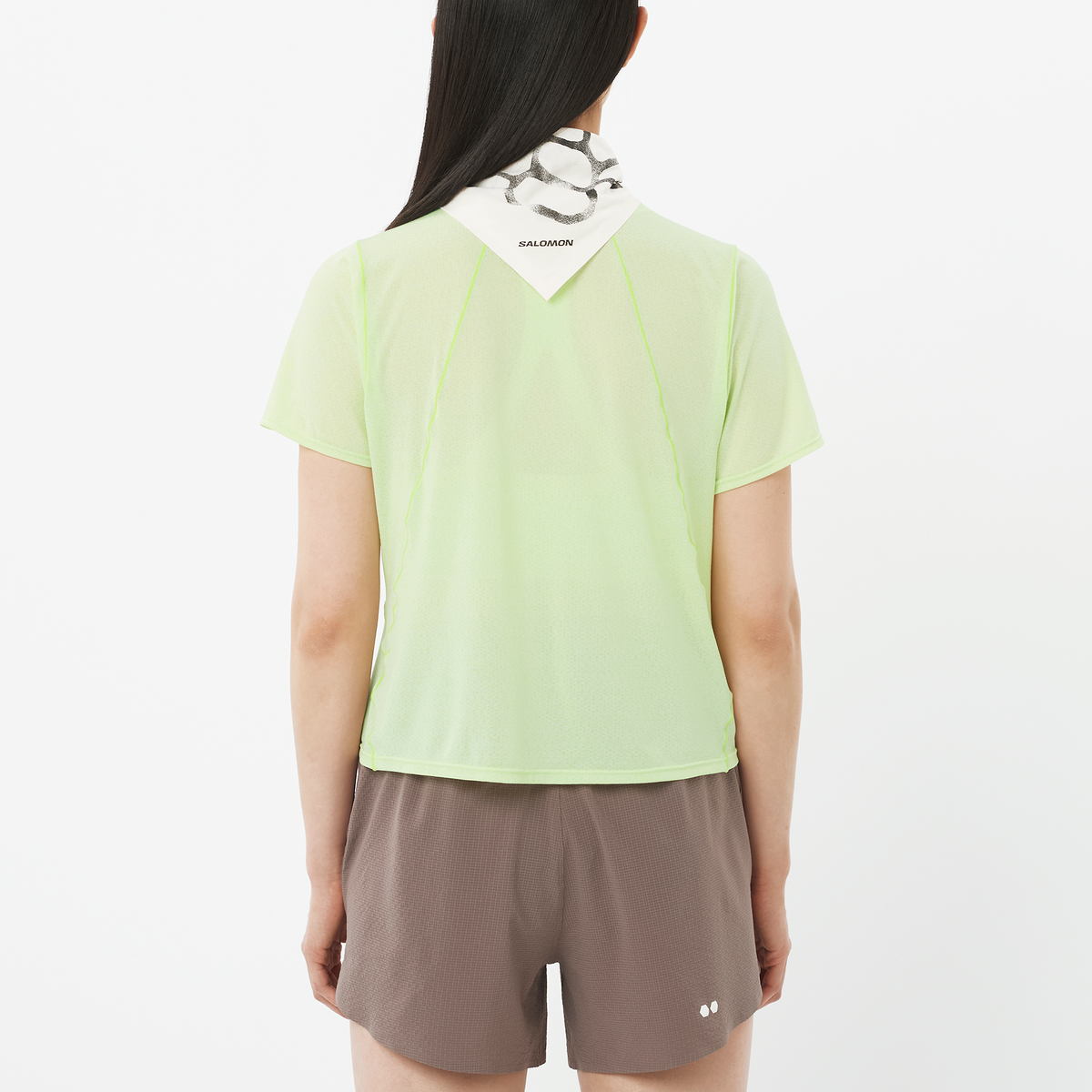 Person wearing a light green t-shirt and brown shorts on a white background
