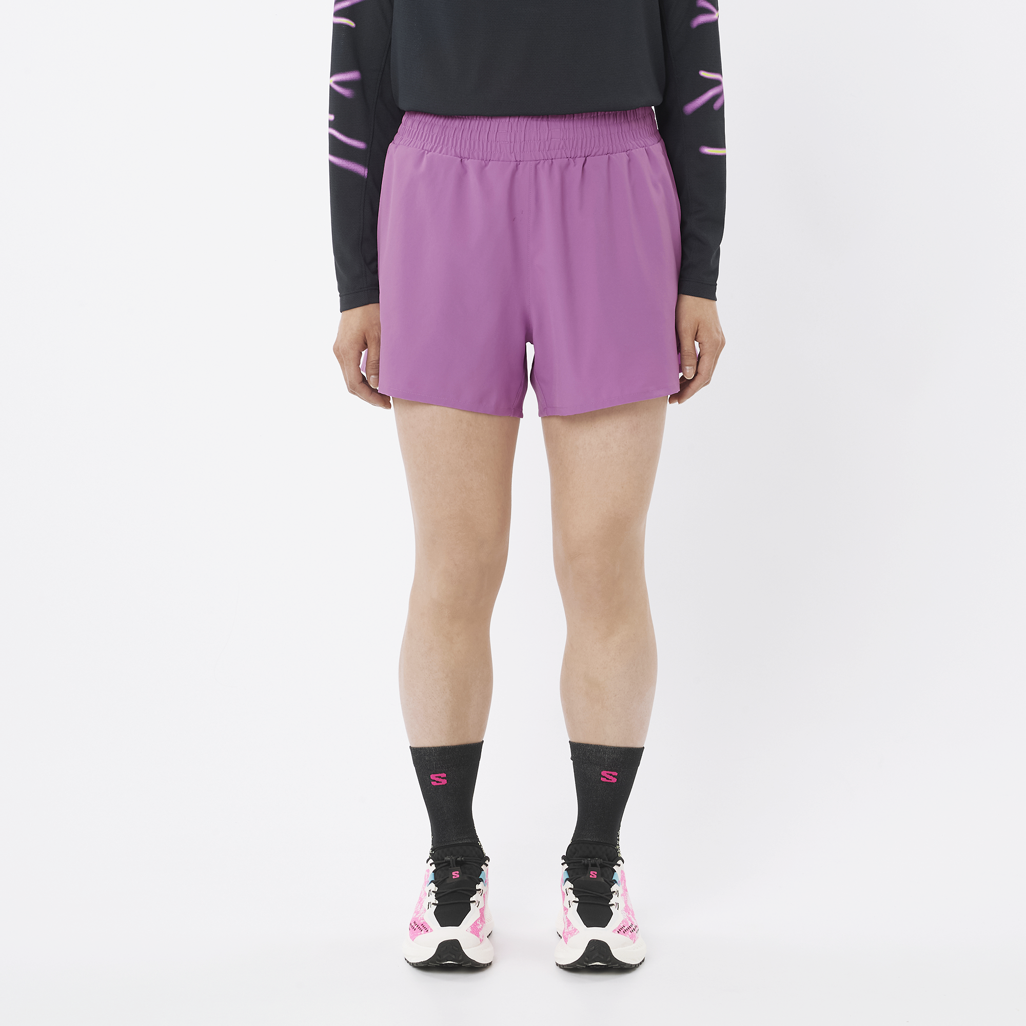 Person wearing purple shorts and black socks with a white background