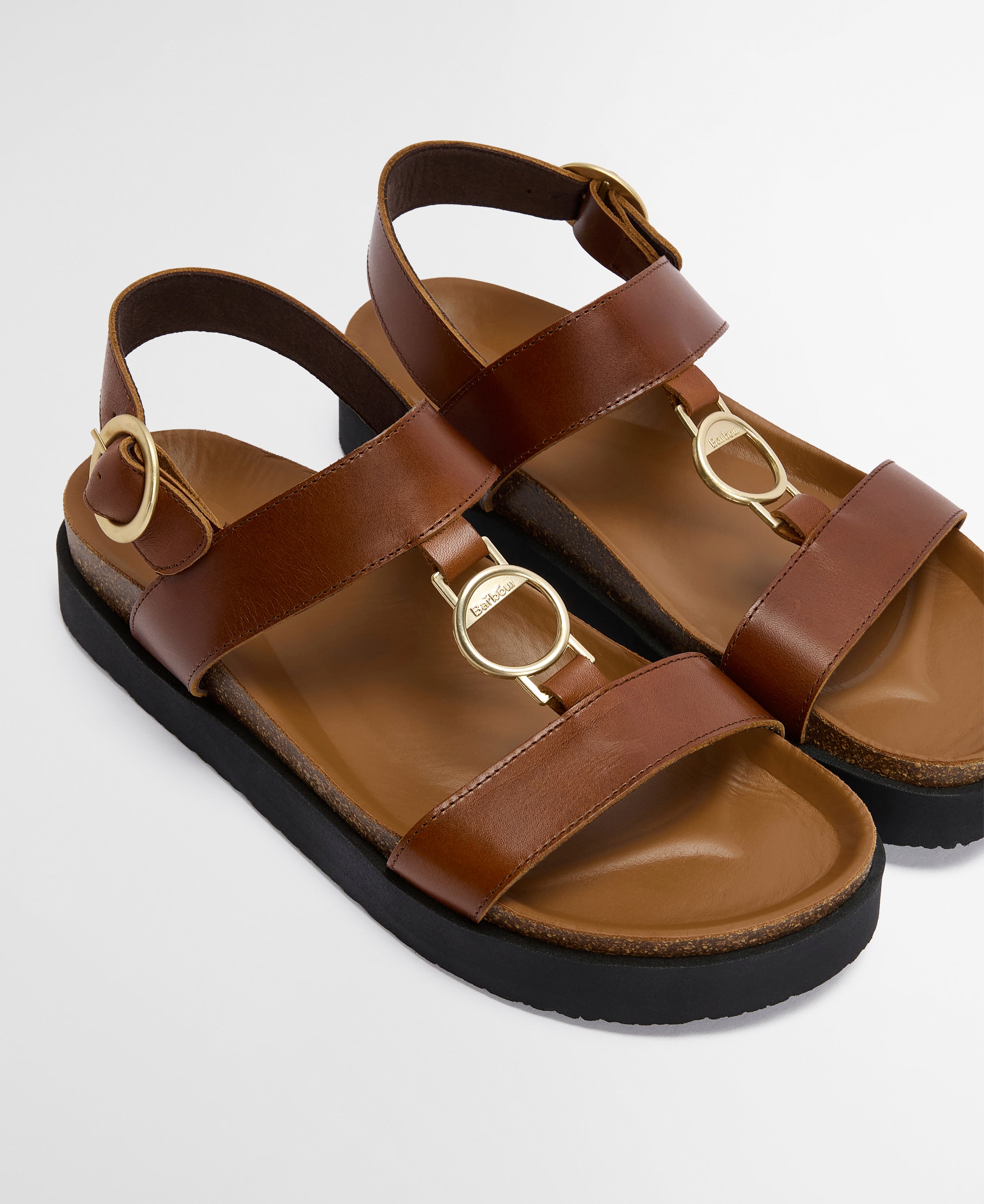 Brown sandals with gold accents on a light gray background