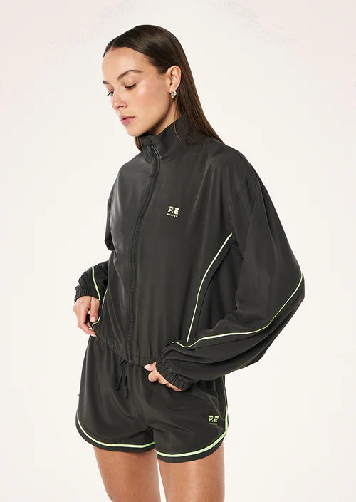 Woman wearing a grey  tracksuit with a logo on a white background