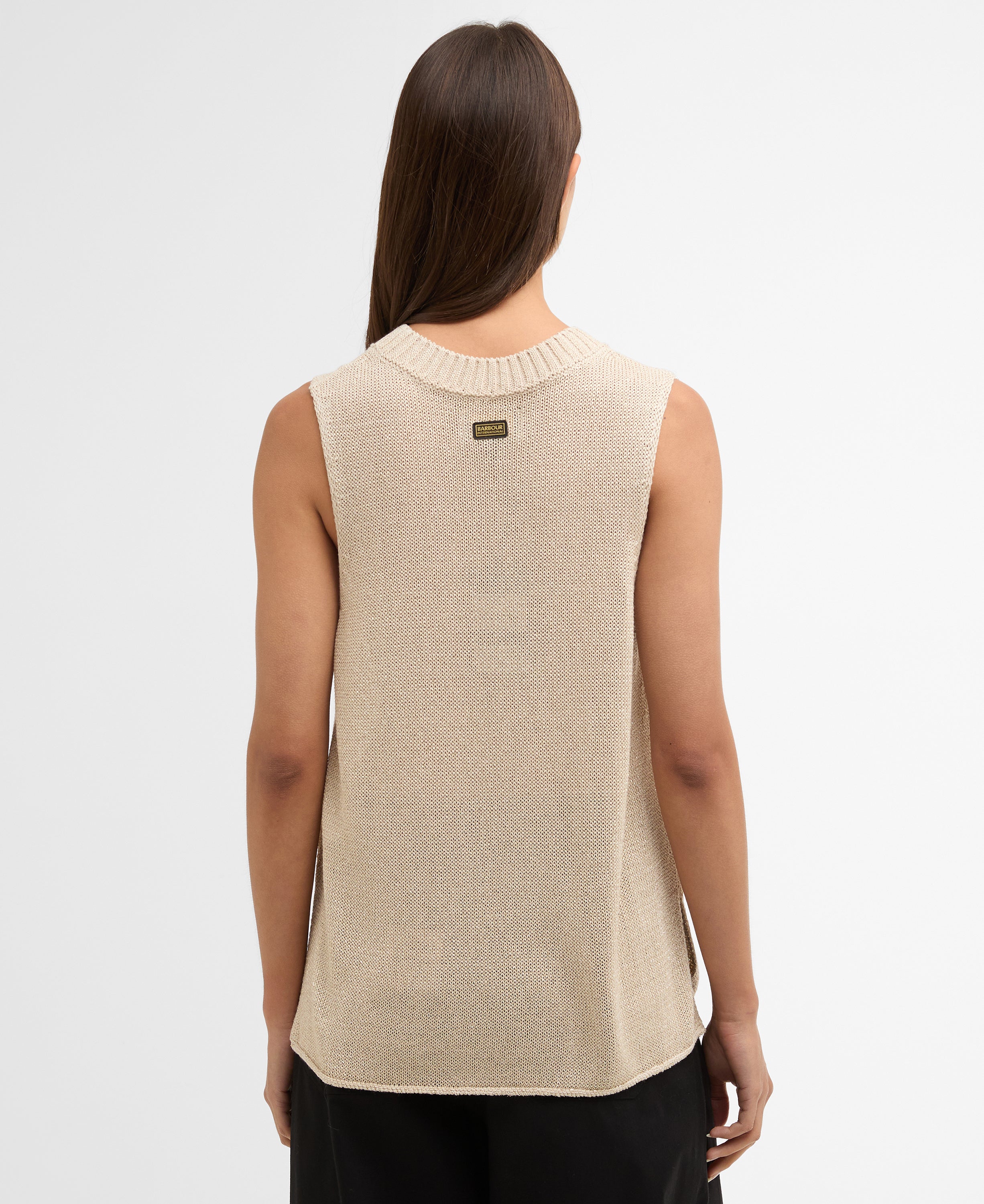 Woman wearing a beige sleeveless sweater on a white background