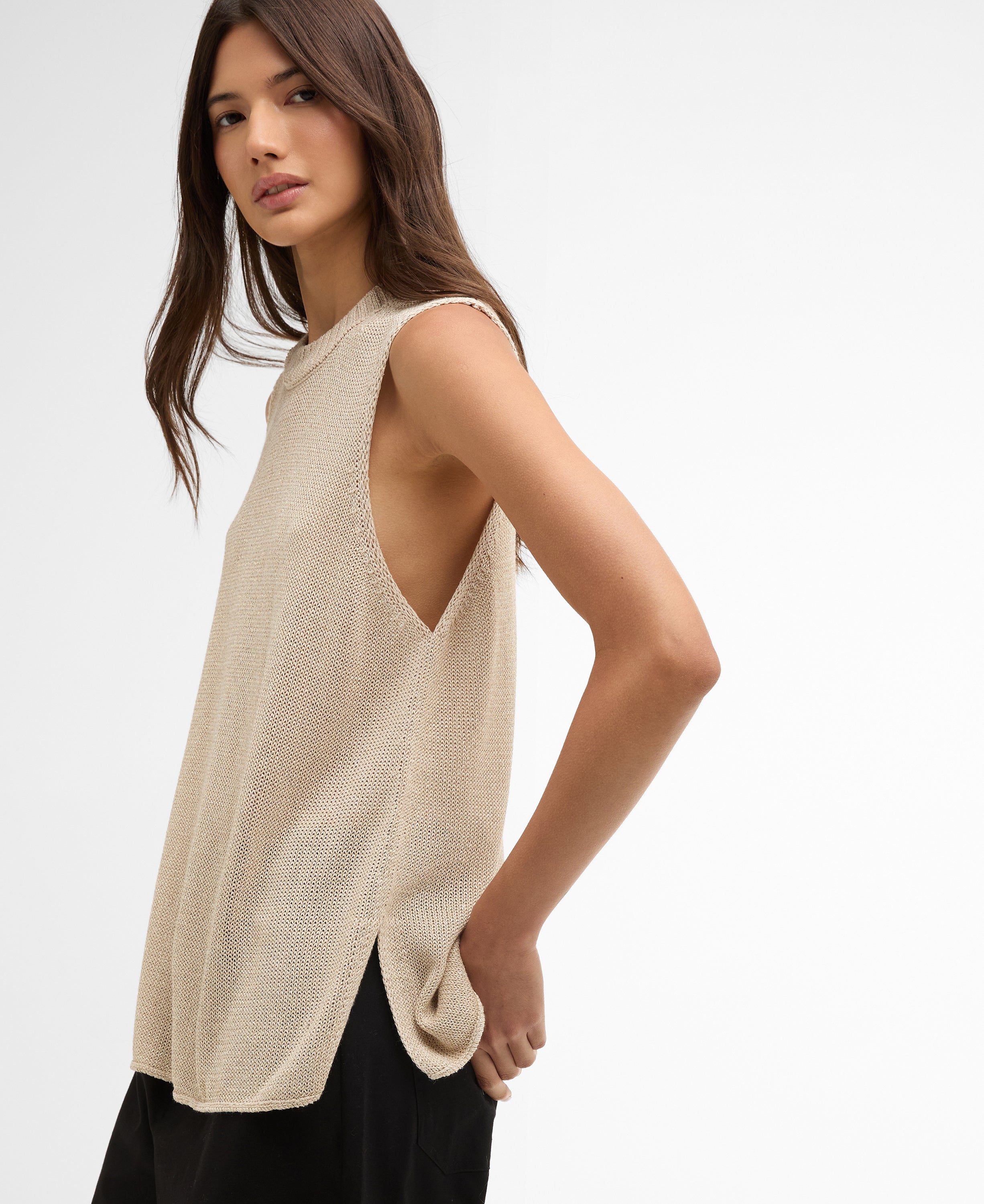 Woman wearing a beige sleeveless top on a white background